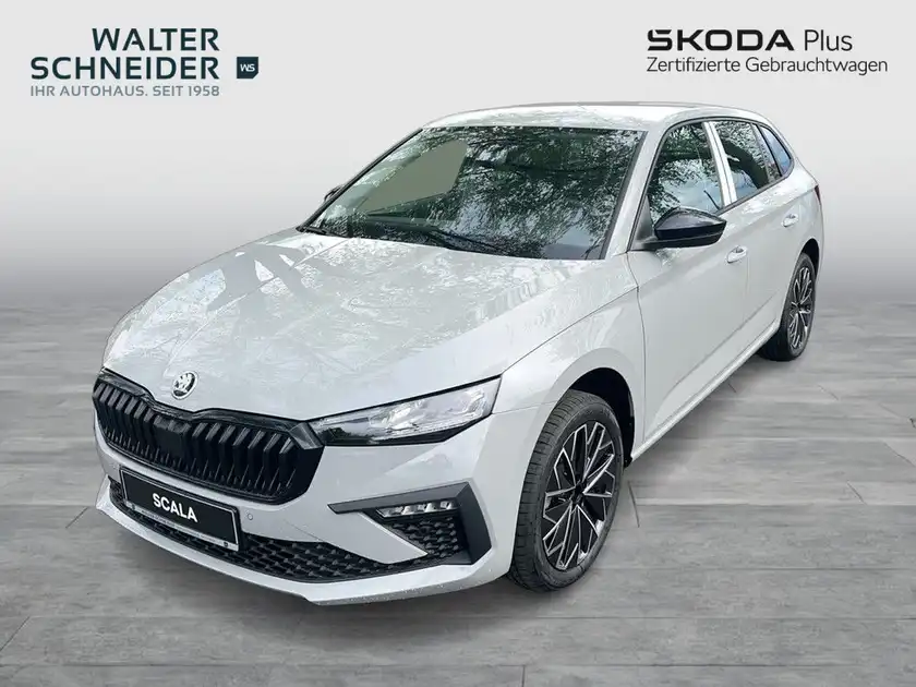 Das Bild zeigt einen weißen ŠKODA SCALA aus der Frontansicht. Im Hintergrund ist das Händlerlogo von Walter Schneider und der Hinweis auf zertifizierte Gebrauchtwagen zu sehen.