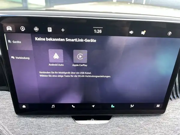 Das Bild zeigt den Innenraum eines ŠKODA SUPERB mit einem modernen Infotainment-Bildschirm, auf dem die Verbindung mit SmartLink-Geräten angezeigt wird.