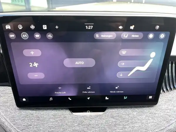 Das Bild zeigt den Innenraum eines Fahrzeugs, mit einem Bildschirm, der das Infotainmentsystem zeigt. Der Bildschirm ist von grauer Interieurfarbe umgeben.