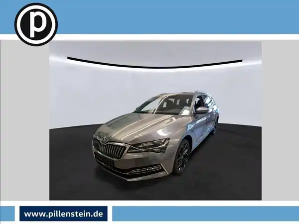 Das Bild zeigt einen silbernen ŠKODA SUPERB von vorne. Es enthält das Händlerlogo und markante Texteinblendungen.