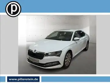 Das Bild zeigt einen weißen ŠKODA SUPERB aus der Frontansicht. Das Händlersymbol ist vorhanden und es gibt markante Texteinblendungen.