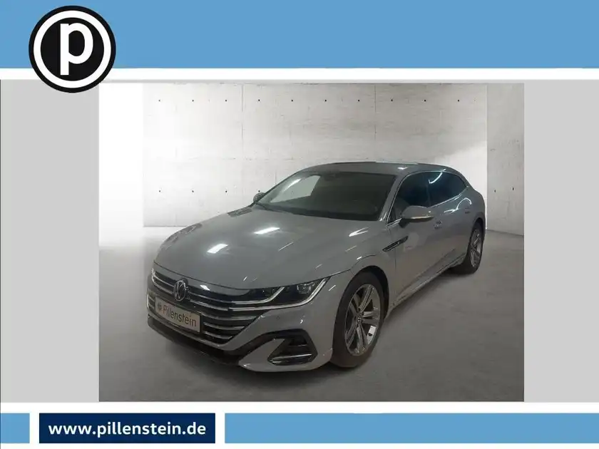 Das Bild zeigt einen silbernen VW Arteon aus der Seitenansicht, mit Händlerlogo im oberen linken Bereich.