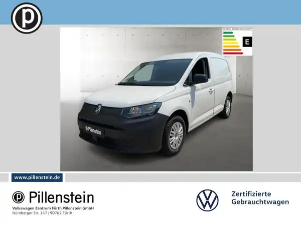 Das Bild zeigt einen weißen VW Caddy von vorne. Es enthält das Händlerlogo von Pillenstein und einige markante Texteinblendungen.