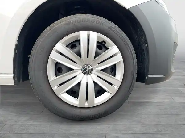 Das Bild zeigt den Reifen und die Felge eines VW Caddy von der Seite, in einer neutralen Umgebung.