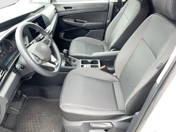 Das Bild zeigt den Innenraum eines VW Caddy, aufgenommen aus der Perspektive des Fahrersitzes. Die Sitze sind schwarz.