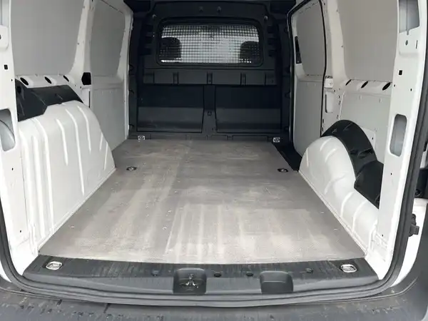 Das Bild zeigt den Innenraum eines VW Caddy, aufgenommen von hinten. Der Innenraum ist in Weiß gehalten und zeigt den Ladebereich.