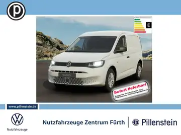 Das Bild zeigt einen weißen VW Caddy von vorne als Anzeige. Es enthält den Hinweis 'Sofort lieferbar' sowie das Händlereigenlogo und Informationen über das Fahrzeug. Der Hintergrund ist eine Landschaft.