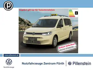 Das Bild zeigt einen beige VW Caddy von vorne. Es handelt sich um eine Anzeige für Taxiunternehmen. Im Bild sind Texteinschreibungen und das Händlerlogo sichtbar.