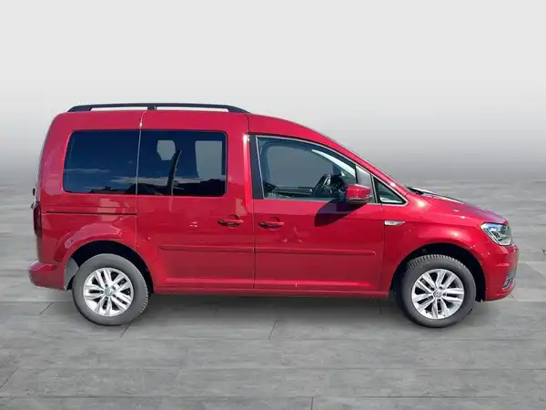 Das Bild zeigt einen roten VW Caddy, aufgenommen von der Seite.