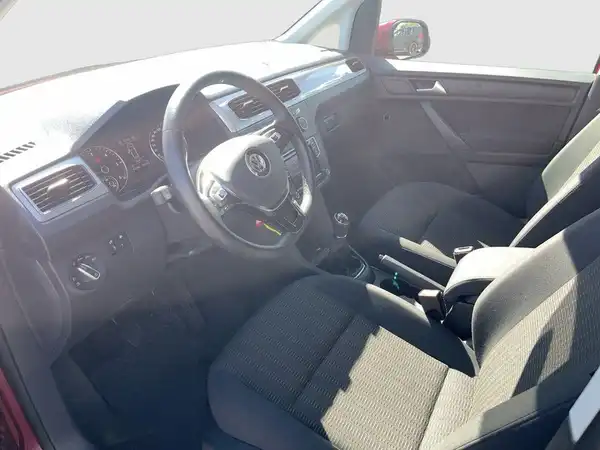 Das Bild zeigt das Innere eines roten VW Caddy mit schwarzem Interieur.