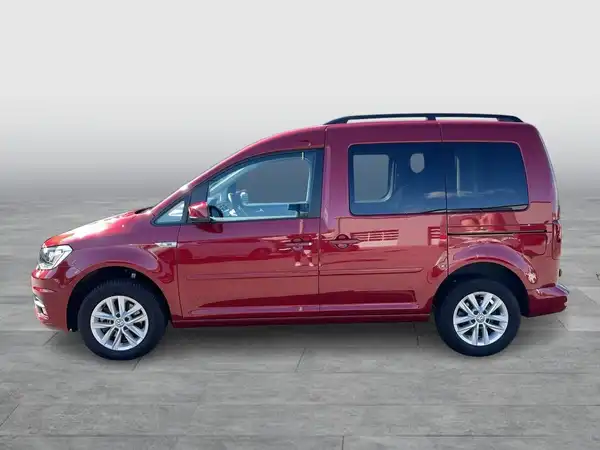 Das Bild zeigt einen roten VW Caddy von der Seite.