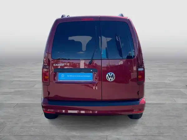 Das Bild zeigt einen roten VW Caddy von hinten.