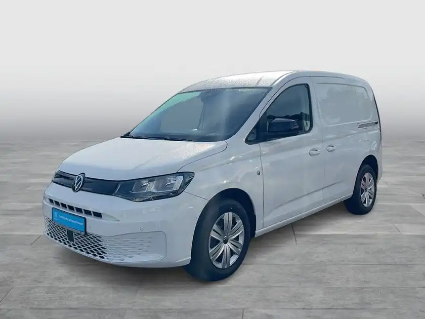 Das Bild zeigt einen weißen VW Caddy aus der Seitenansicht, aufgenommen vor einem neutralen Hintergrund mit Händlerlogo und weiteren Texteinblendungen.