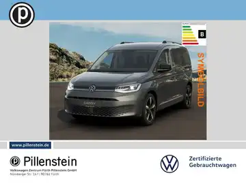 Das Bild zeigt einen grauen VW Caddy, aufgenommen von vorne. Im Bild ist das Händlerlogo von Pillenstein sichtbar, sowie Markierungen in Form von Text.