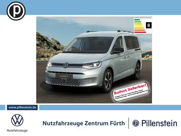Das Bild zeigt einen silbernen VW Caddy von vorne. Es enthält das Händlerlogo und markante Texteinblendungen bezüglich der sofortigen Lieferbarkeit.