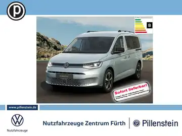 Das Bild zeigt einen silbernen VW Caddy von vorne. Es enthält das Händlerlogo und markante Texteinblendungen bezüglich der sofortigen Lieferbarkeit.