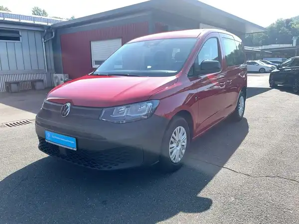 Das Bild zeigt einen roten VW Caddy von der Seite. Es sind Händlerlogo und Texteinblendungen zu sehen.