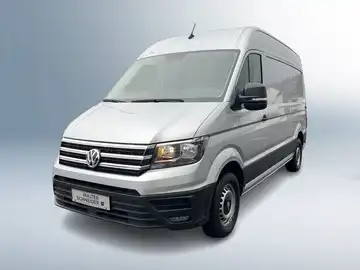Das Bild zeigt einen silbernen VW Crafter von vorne, mit einem Händlerlogo und markanten Texteinblendungen im Bild.