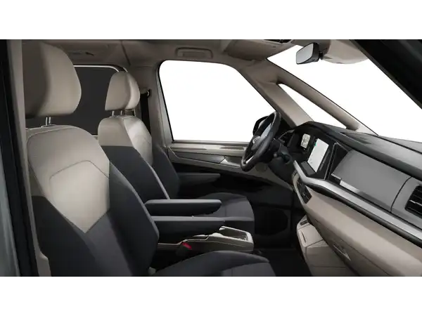 Das Bild zeigt den Innenraum eines VW Multivan, hauptsächlich in hellbeige und schwarz.