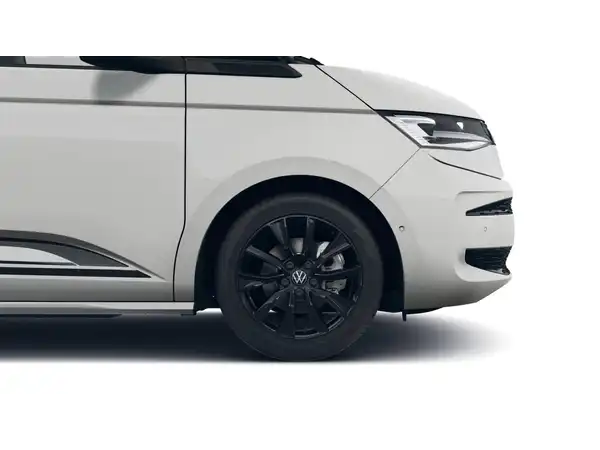 Das Bild zeigt einen weißen VW Multivan von der Seite. Die Felgen sind schwarz.