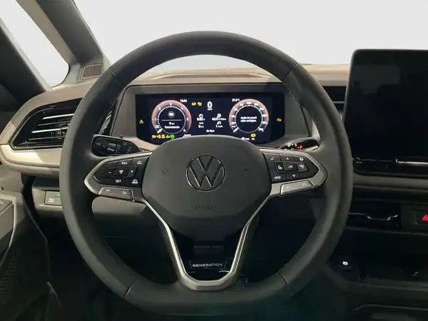 Das Bild zeigt den Innenraum eines VW Multivan, besonders das Lenkrad und das Armaturenbrett in beiger Farbe.