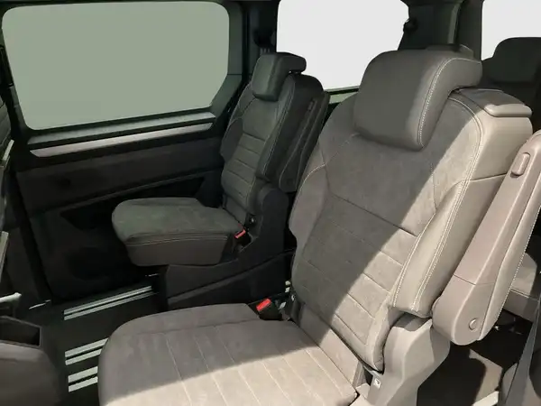 Das Bild zeigt den Innenraum eines VW Multivan mit grauen Sitzen.