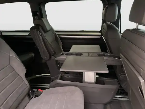 Innenaufnahme des Fahrzeugs, zeigt die Sitze und einen Tisch im Interieur. Die Innenfarbe ist schwarz.