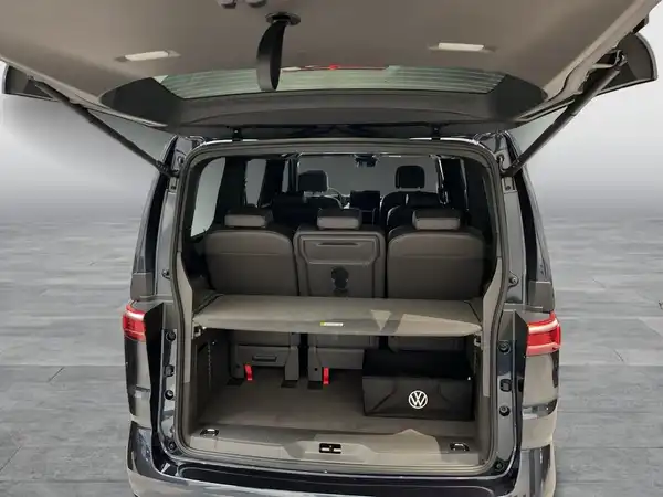 Das Bild zeigt den Kofferraum eines VW Multivan von hinten. Die Innenausstattung ist in Schwarz.