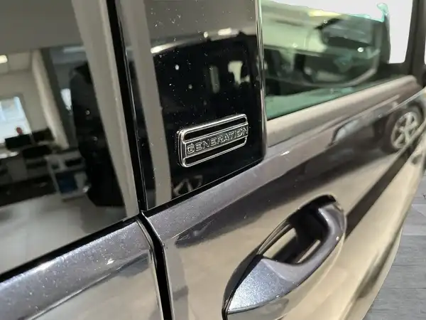 Das Bild zeigt eine Seitenansicht eines schwarzen VW Multivan. Es ist eine Nahaufnahme des Türbereichs.