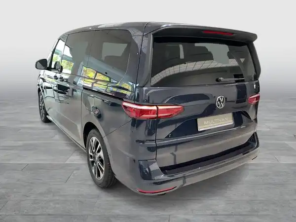 Das Bild zeigt einen Volkswagen Multivan in der Farbe grau, aufgenommen von hinten.