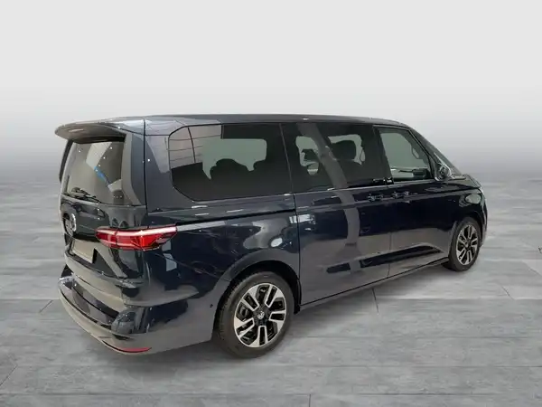 Das Bild zeigt einen dunkelblauben VW Multivan von der Seite.