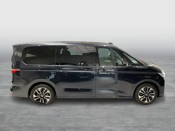 Das Bild zeigt einen dunkelblauen VW Multivan, aufgenommen von der Seite.