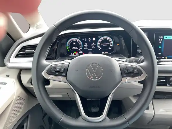 Das Bild zeigt das Innere eines VW Multivan mit Blick auf das Lenkrad und das Armaturenbrett. Die Innenfarbe ist hell.