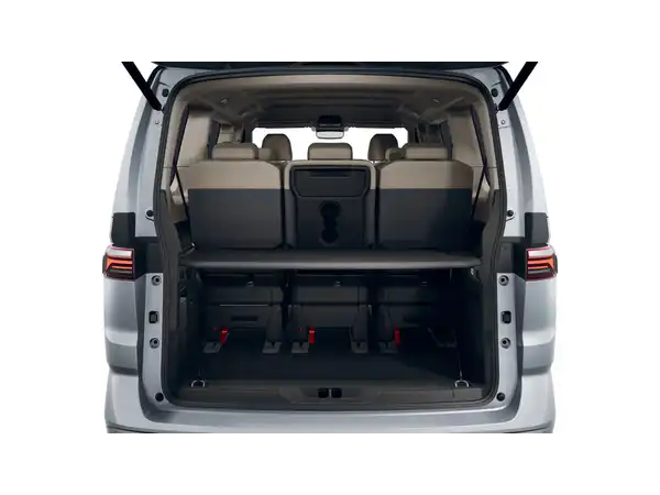 Das Bild zeigt die Rückansicht des VW Multivan in silberner Farbe mit geöffnetem Kofferraum und sichtbaren Sitzen im Fond.