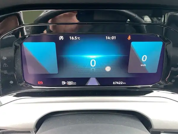 Das Bild zeigt das Inneninterieur eines VW Golf Variant in Grau. Es ist eine Aufnahme der Fahrerkonsole mit einem Display, das Navigationsinformationen zeigt. Es sind keine Händlerlogos sichtbar, aber es gibt markante Texteinblendungen auf dem Bildschirm.