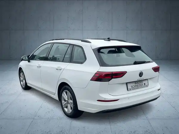 Das Bild zeigt den hinteren Teil eines weißen VW Golf Variant. Es ist ein Fahrzeugbild, das aus der Rückansicht aufgenommen wurde, mit einem Händlerlogo und zusätzlichem Text.