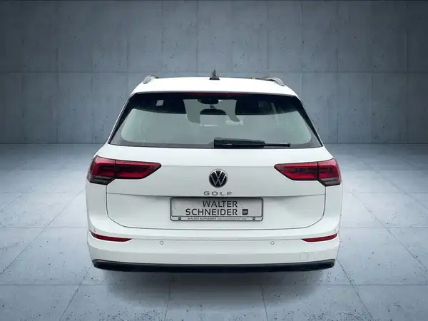 Ein Bild eines weißen VW Golf Variant, von der Seite aufgenommen.