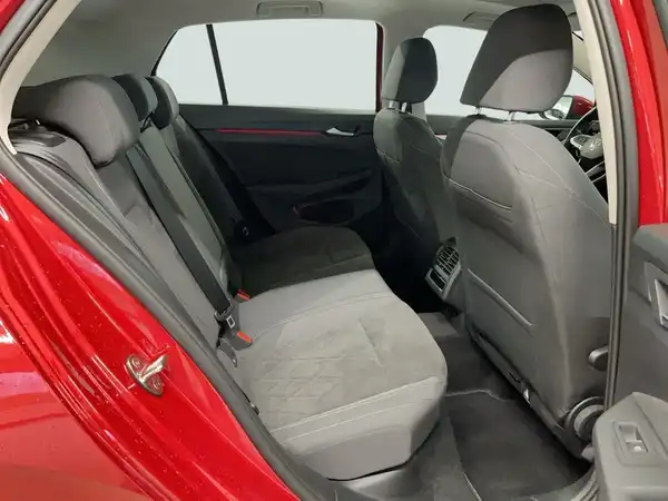 Das Bild zeigt den Innenraum eines roten VW Golf, genauer gesagt die Rückbank. Die Sitze sind in schwarz/grau gehalten.