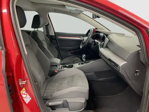 Das Bild zeigt das Innenraum eines roten VW Golf mit grauen Sitzen.