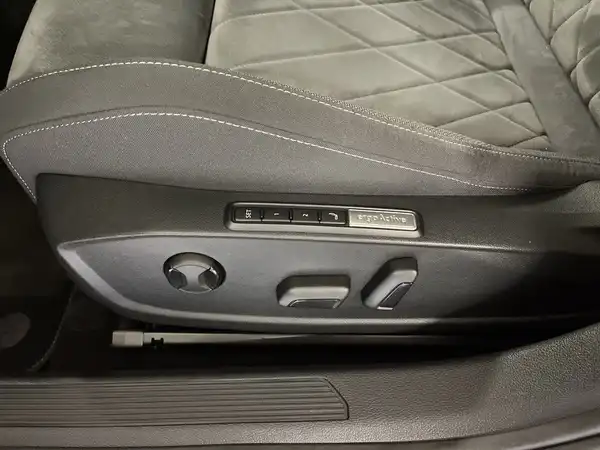 Das Bild zeigt die Innenaufnahme eines VW Golf mit einem grauen Interieur, insbesondere die Türverkleidung mit Bedienelementen.