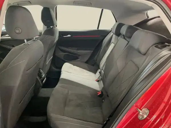 Das Bild zeigt die Innenaufnahme des Rücksitzbereichs eines roten Fahrzeugs mit schwarzem Interieur.