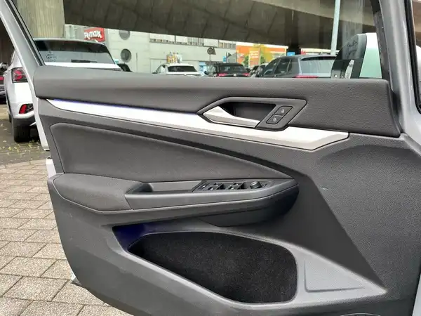 Das Bild zeigt die Innenseite einer Autotür, die vermutlich zu einem VW Golf gehört. Die Tür hat eine schwarze Farbe mit einigen silbernen Akzenten.