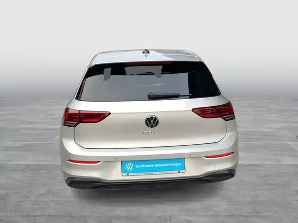 Das Bild zeigt einen silbernen VW Golf von hinten. Es enthält das Händlerlogo und markante Texteinblendungen.