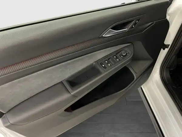Das Bild zeigt eine Innenaufnahme der Fahrertür eines weißen Fahrzeugs mit grauem Interieur.