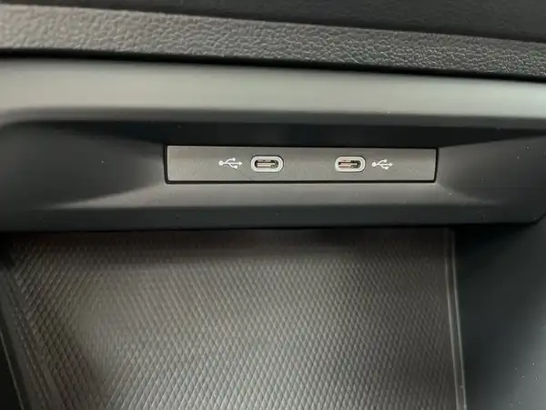 Eine Innenaufnahme des Fahrzeuginnenraums, die zwei USB-Anschlüsse zeigt. Die Interieurfarbe ist schwarz.