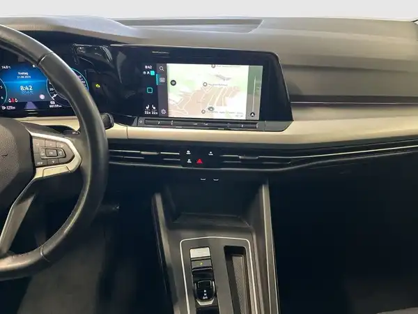Das Bild zeigt das Innenraum eines VW GOLF VARIANT mit einem schwarzen Interieur und einem Navigationsbildschirm.