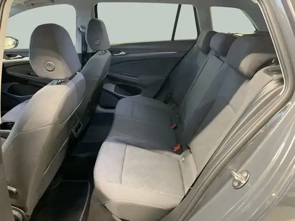 Das Bild zeigt den Innenraum eines VW GOLF VARIANT, insbesondere die Rückbank, die grau ist und aus Stoff besteht.