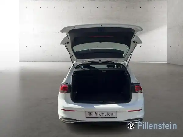 Das Bild zeigt die Rückansicht eines weißen VW Golf mit geöffnetem Kofferraum.