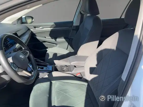 Das Bild zeigt den Innenraum eines VW Golf mit hellgrauen Sitzen. Das Händlerinlogo ist sichtbar.