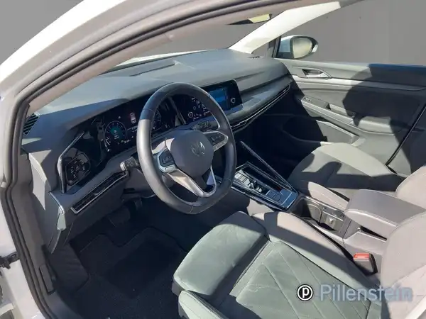 Das Bild zeigt den Innenraum eines Fahrzeugs, das schwarz ist und eine moderne Armaturentafel aufweist.